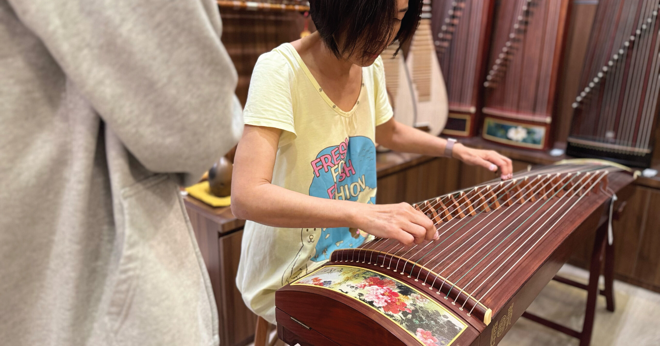Customer testing a Guzheng in-store at Eason Music Singapore